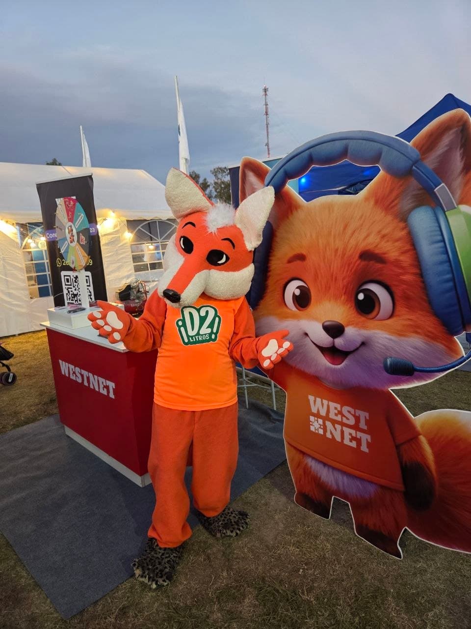 Mascota zorro de Westnet junto a su cartel troquelado en el stand de la marca