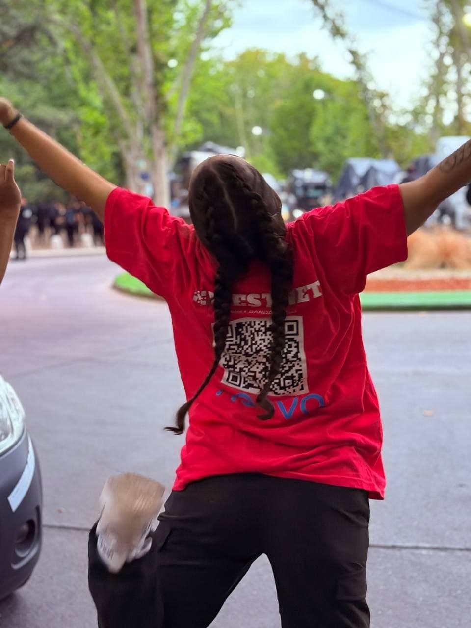 Persona con remera de Westnet festejando con los brazos en alto en la calle durante Vendimia