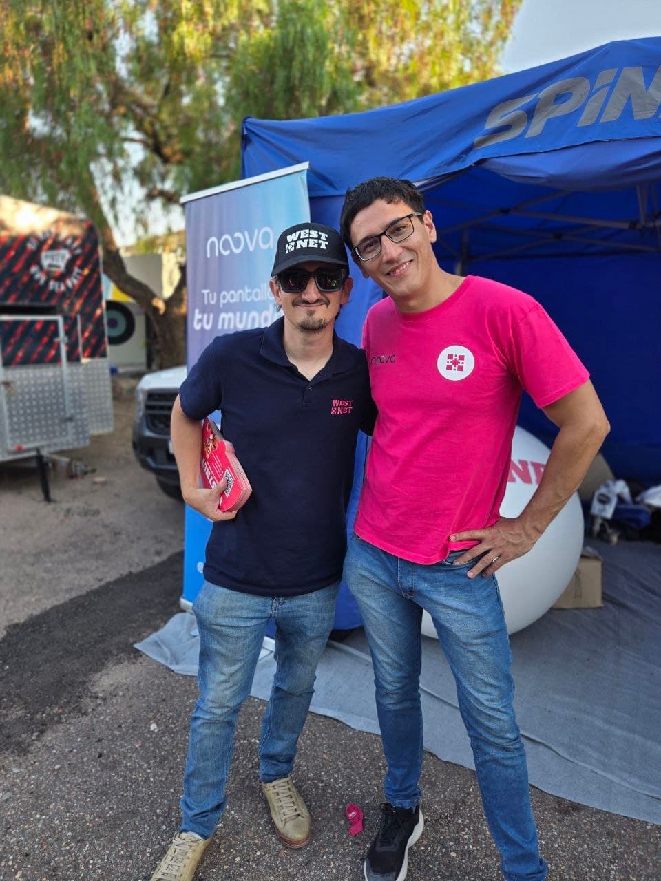 Dos integrantes de Westnet posando frente al stand de la marca en Vendimia